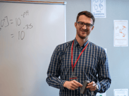 man standing in front of white board