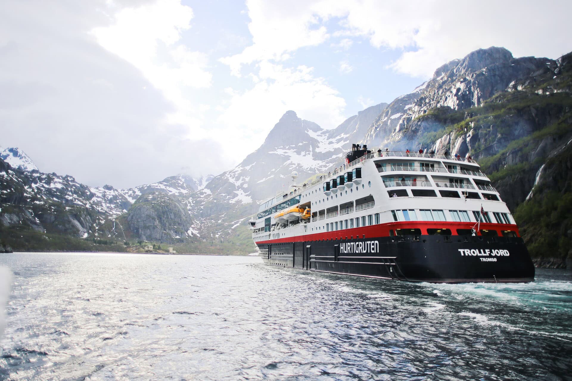 cruise ship surrounded by snow capped mountains