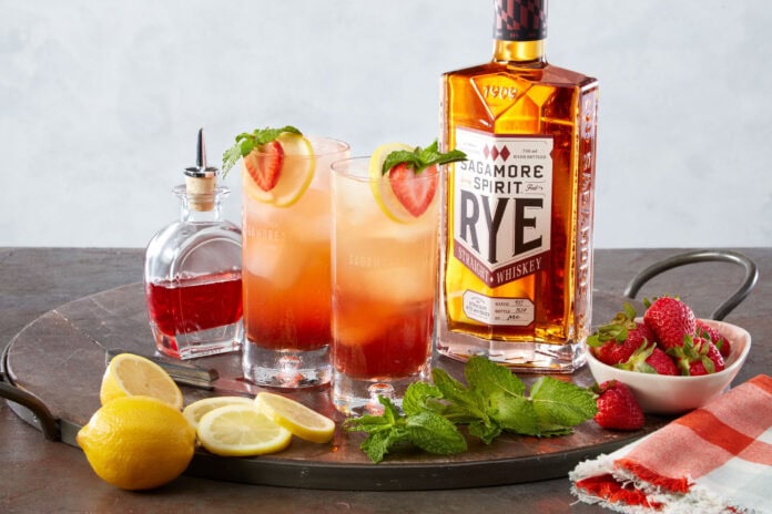strawberry cocktails with bottle of rye whiskey