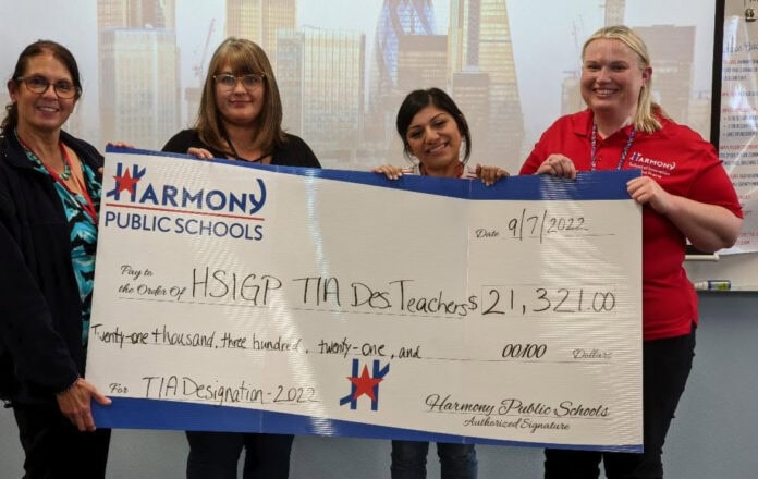 Four people holding large check