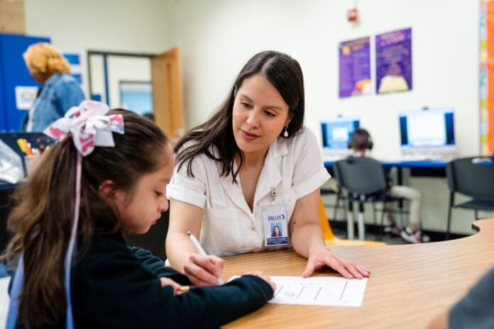 teacher with student at desk