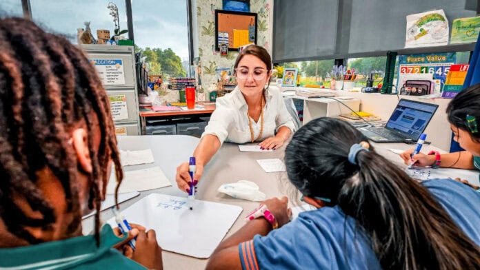 teacher with students at a table