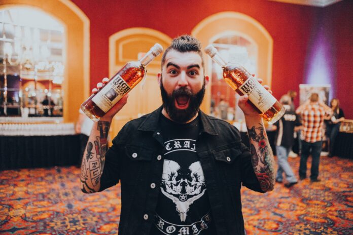guy holding whiskey bottles